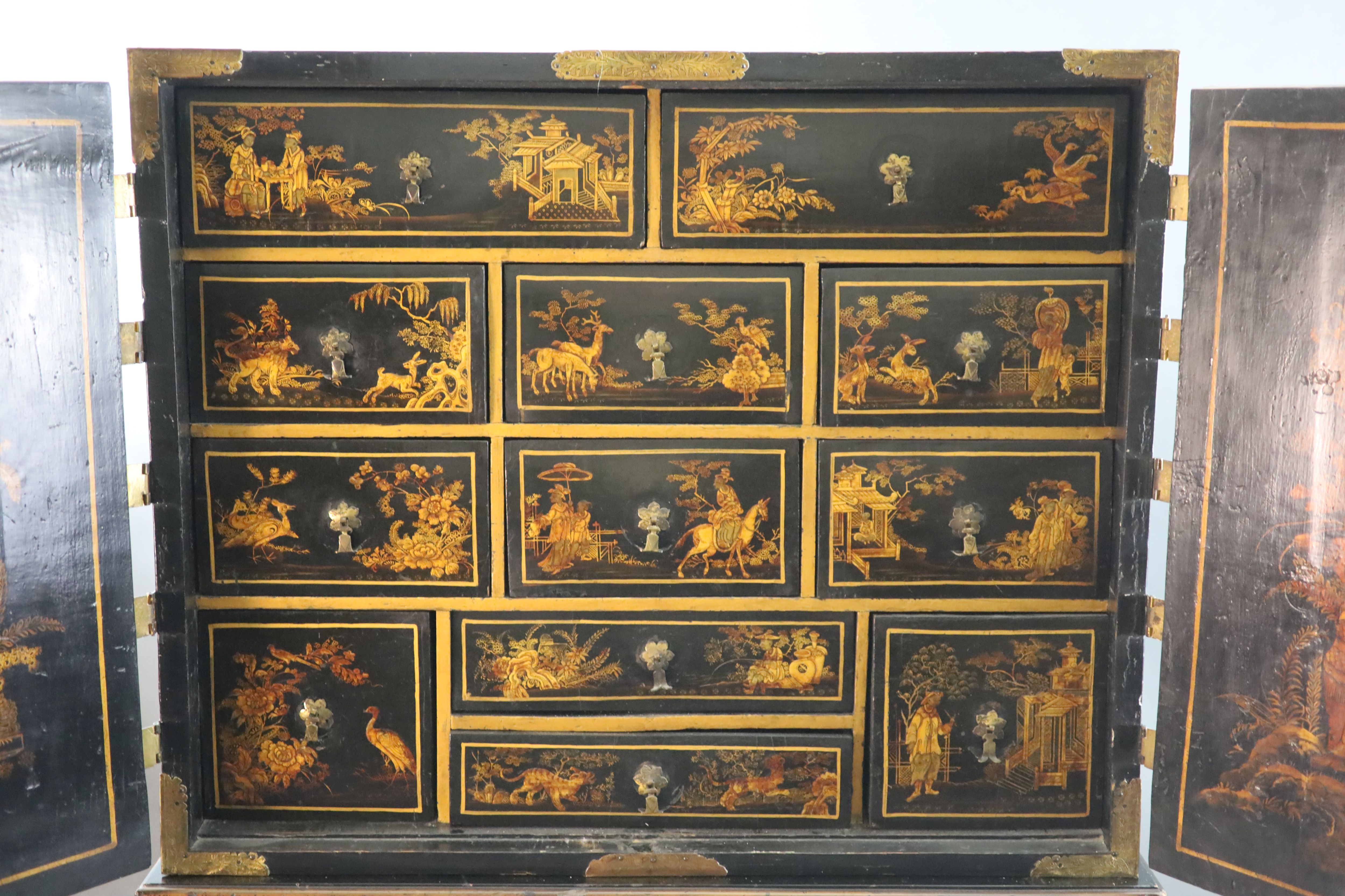 A late 17th century japanned cabinet on later stand W. 3ft. 1in. D. 1ft 4.5in. H. 2ft. 6in. Height overall 6ft 3in.